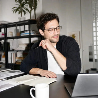 Mann arbeitet am Tisch mit Laptop