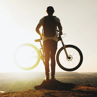 Mann mit Fahrrad auf Berg