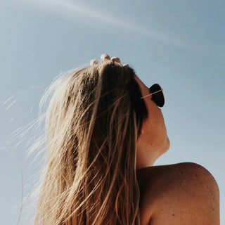 Frau steht in der Sonne, entspannt