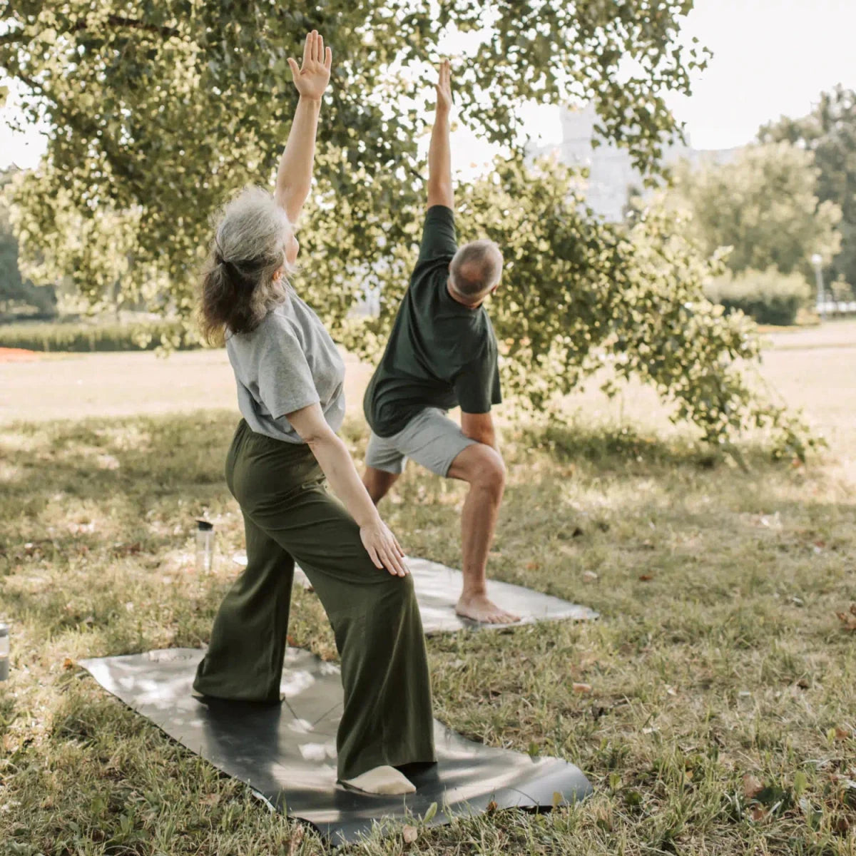 2 Menschen machen draußen Yoga zum entspannen und wohl fühlen