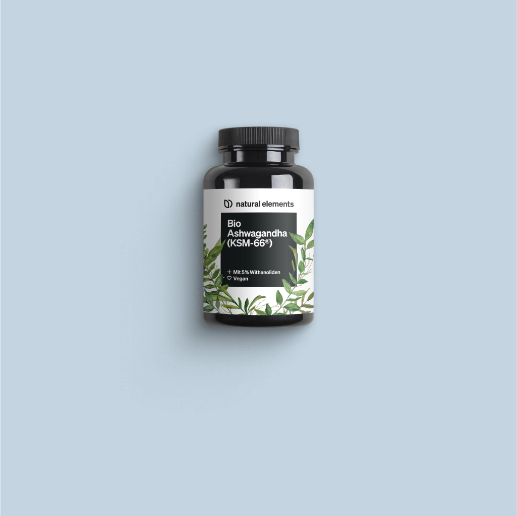 Eine Flasche Vitamin C mit grünen Blättern auf blauem Hintergrund, die natürliche Elemente zur Geltung bringt.