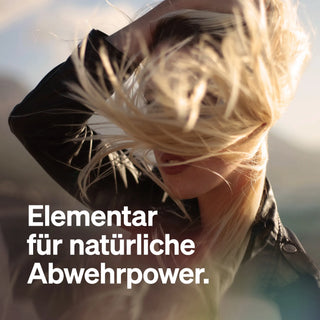 Eine Person mit blondem Haar, das ins Gesicht weht. Text: "Elementar für natürliche Abwehrkraft.