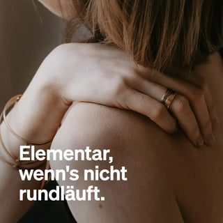 Eine Frau mit Ring und Armband stützt ihre Hand auf ihre nackte Schulter. Der deutsche Text lautet: "Elementar, wenn's nicht rundläuft.
