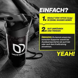 Eine schwarze Shaker-Flasche mit dem "natural elements"-Logo steht auf einer schwarzen Fläche. Textanweisungen erklären das Mischen und die Verwendung des Produkts in Wasser mit fettgedruckten Überschriften und gelber Hervorhebung.